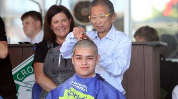 Cronulla High School student James Young braves the shave, with his father Mark in control. Picture by Chris Lane







