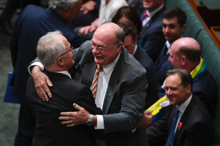 Liberal MP Warren Entsch hugs Australian Prime Minister Malcolm Turnbull after the passing of the Marriage Amendment Bill in the House of Representatives at Parliament House in Canberra, Thursday, December 7, 2017. (AAP Image/Lukas Coch) NO ARCHIVING