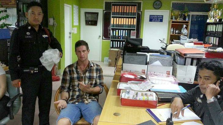 Jacob Saveisberg with police after allegedly stealing two raw prawns.  Photo: Phuketwan 