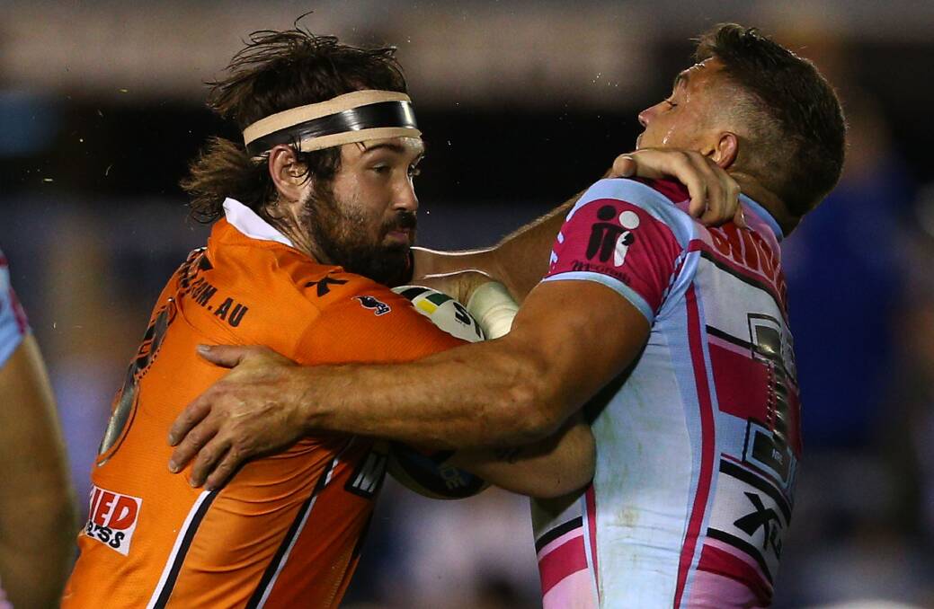 Aaron Woods of the Tigers is tackled by Chris Heighington during the round 10 NRL match between the Cronulla-Sutherland Sharks and the Wests Tigers at Remondis Stadium. Picture: Renee McKay/Getty Images