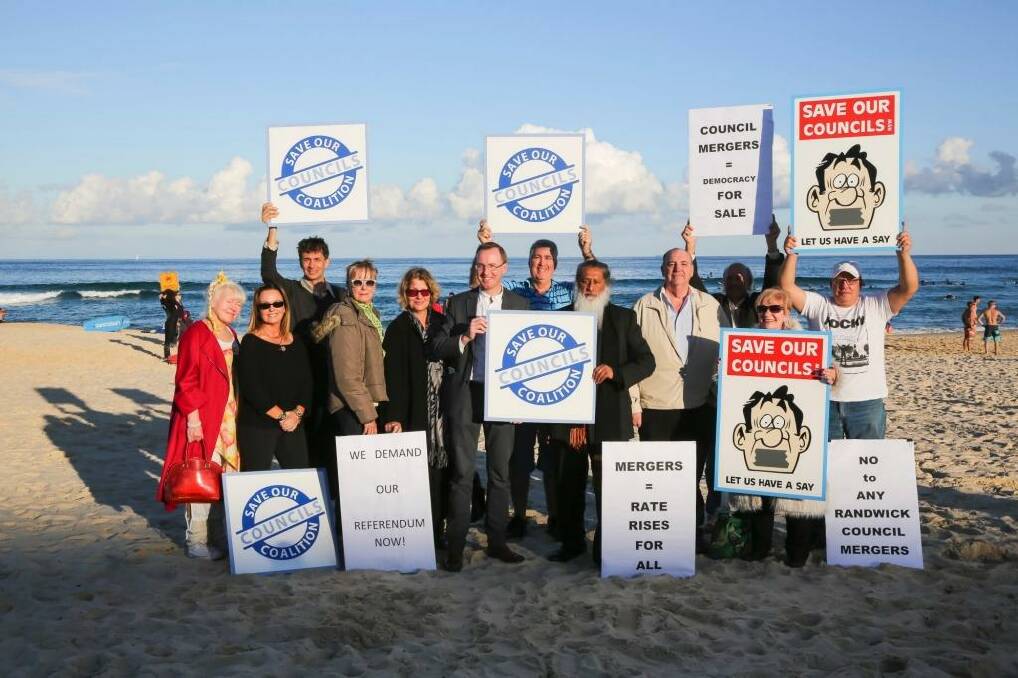Greens MP David Shoebridge with residents and councillors, holding up rally signs on Bondi beach after the Keep it Local Forum at Bondi Pavilion on June 14. Photo: Anna Kucera