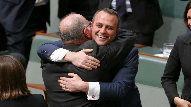Liberal MP Tim Wilson is embraced by his colleague Warren Entsch after delivering his maiden speech. Photo: Alex Ellinghausen
