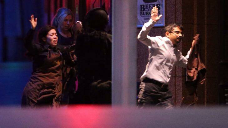 Hostages are assisted from the Lindt Chocolat Cafe in Martin Place. Photo: Andrew Meares