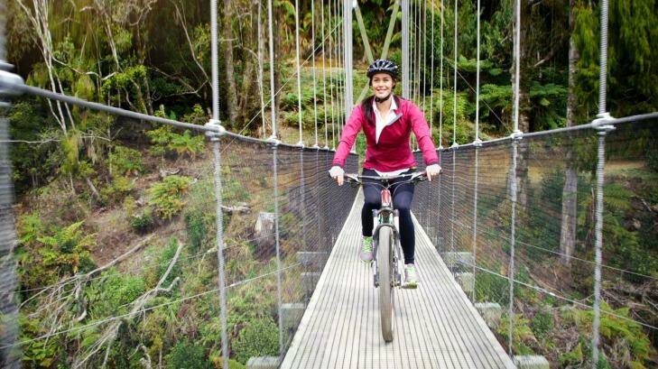 Megan Gale crossing the impressive Maramataha Suspension Bridge on The Timber Trail. Some of New Zealand’s highest and longest suspension bridges feature on this trail.