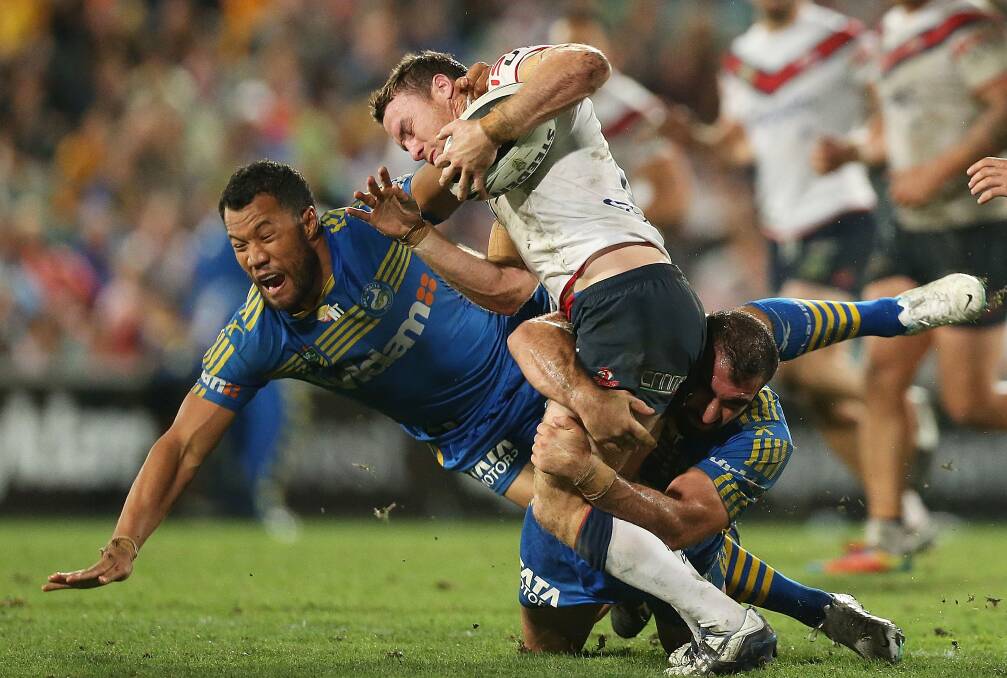 SYDNEY, AUSTRALIA - APRIL 12: James Maloney of the Roosters is tackled by Tim Mannah and Joseph Paulo of the Eels during the round 6 NRL match between the Parramatta Eels and the Sydney Roosters at Pirtek Stadium on April 12, 2014 in Sydney, Australia. (Photo by Mark Metcalfe/Getty Images)