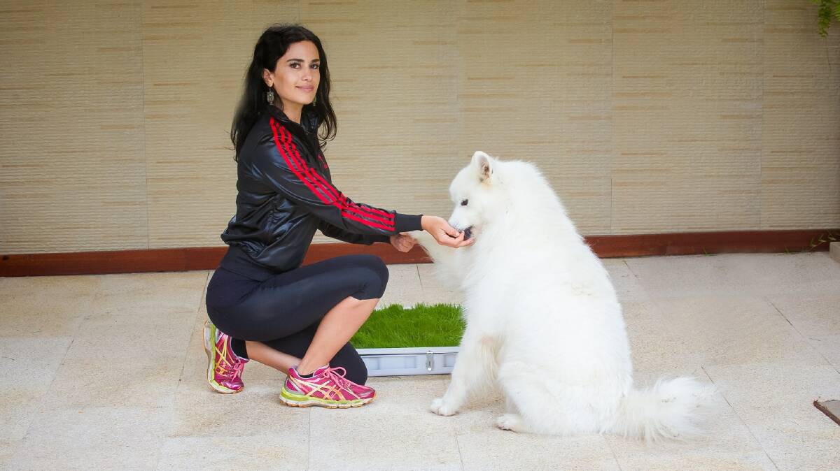 Potty Plant founder Julia Sakr, with her dog. Potty Plant is a grass toilet for dogs, to help prevent odour and for those in apartment buildings. Picture: Supplied