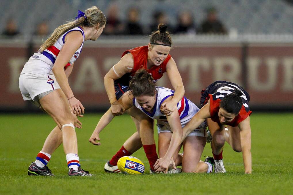 Emma Kearney (centre) of the Western Bulldogs competes for the ball against Melbourne in the inaugural AFL women's match at the MCG. Photo: Michael Copp