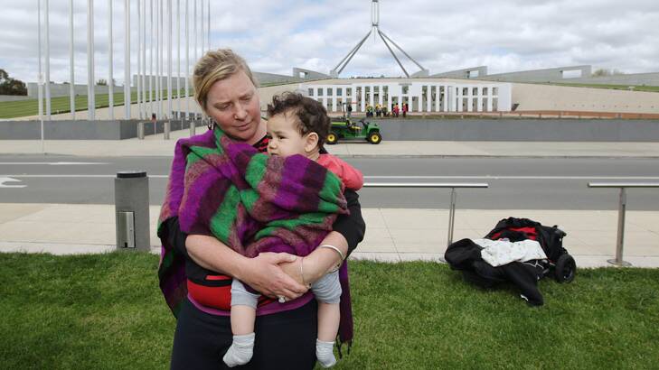 A single mum protests outside Parliament House.