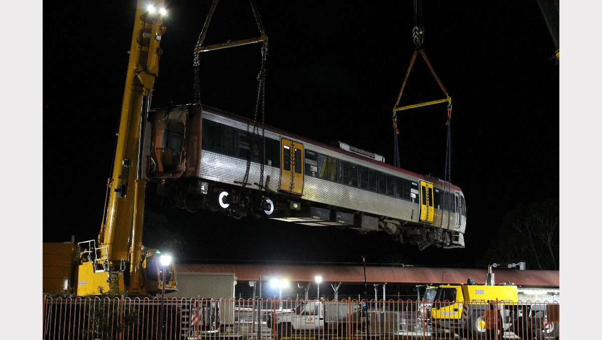 The front carriage of the crashed train is lifted out of the station building.