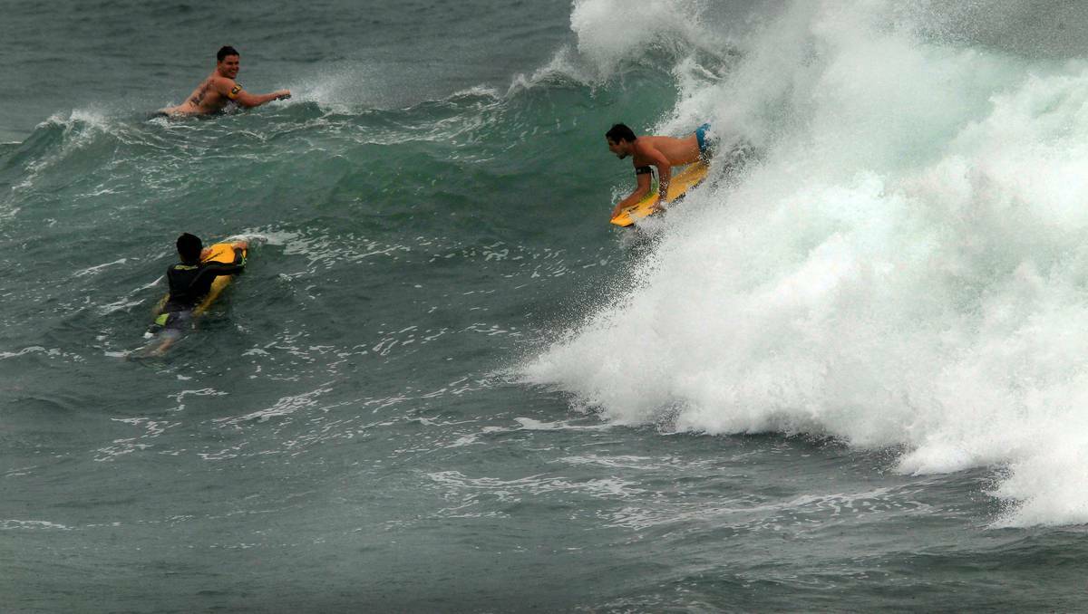 Surfers and body boarders took on big waves on Monday at The Farm, Wollongong. Pictures: SYLVIA LIBER