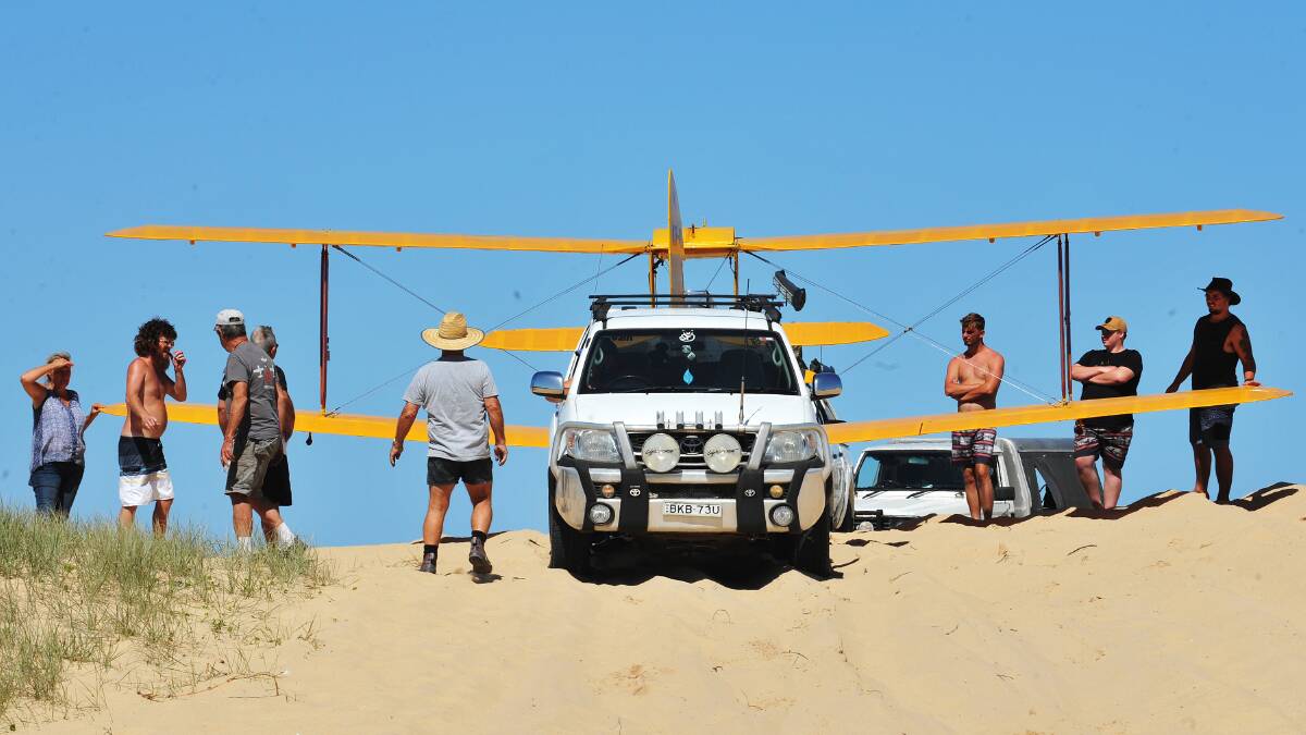 Wayne Franklin described the landing as 'remarkable' as he tows the Tiger Moth off the beach.