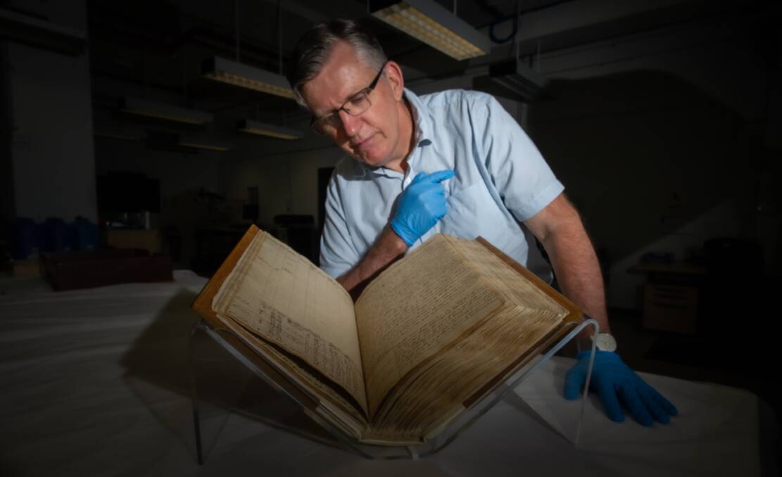 Guy Hansen, director of exhibitions at the National Library of Australia, with one of Captain James Cook's journals. Picture: Karleen Minney