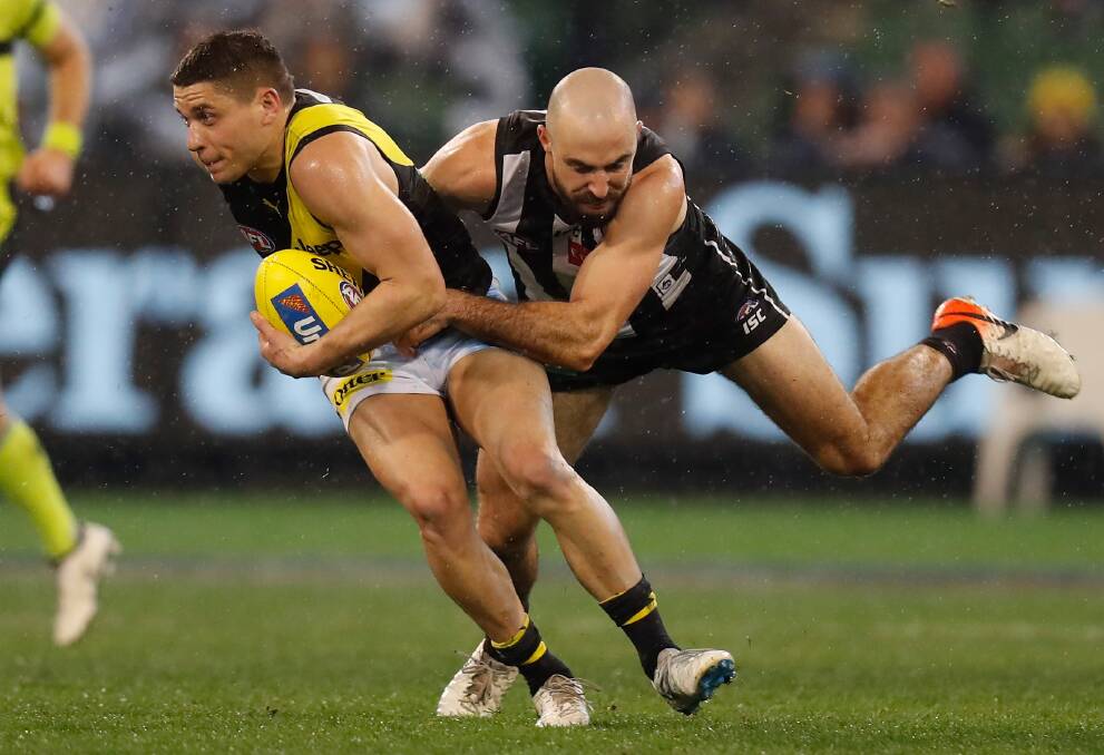 The Tigers' Dion Prestia is tackled by Steele Sidebottom of the Magpies during the AFL round 19 match last year. The two sides clash on Thursday night, signalling the resumption of footy for 2020. Photo: Michael Willson/Getty Images