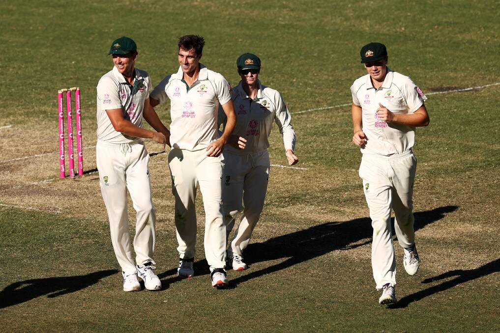 Australia's Pat Cummins celebrates with his teammates after dismissing Rohit Sharma. Photo: Cameron Spencer/Getty Images