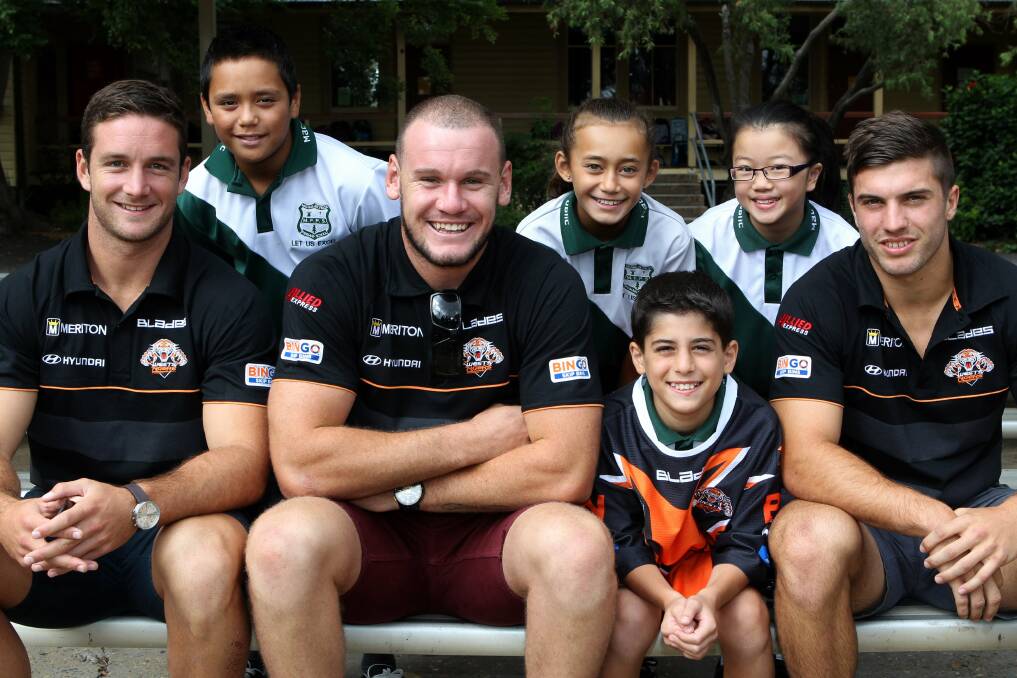 Wests Tigers players visiting Macquarie Fields Public School. Players from left Tim Moltzen, Jack Buchanan & James Tedesco with students Josh Obeido (jersey), Ethan Mauala, Krystal Tiata and Stephanie Ng. Picture: Jonathan Ng