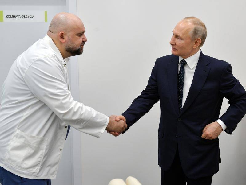 Russian President Vladimir Putin shakes hands with hospital chief Denis Protsenko.