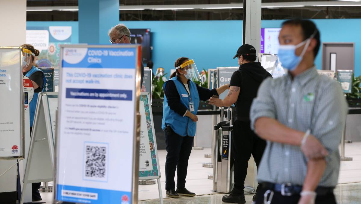 A member of the public is greeted and given information at the entrance to the South Western Sydney Vaccination Centre in July. Picture: Getty Images