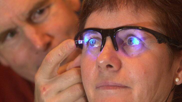 Professor Leon Lack from Flinders University adjusts a prototype of his light-emitting diode (LED) glasses which help alleviate the effects of jet lag.