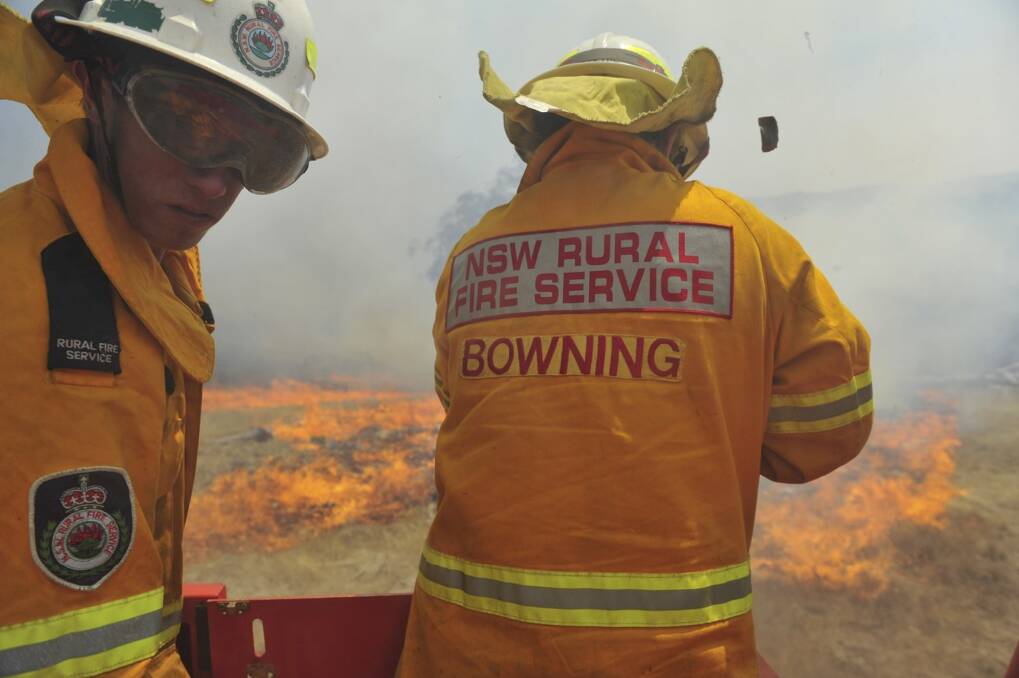 Fire fighters from the Rural Fire Service help extinguish a grass fire in Bowning, New South Wales.