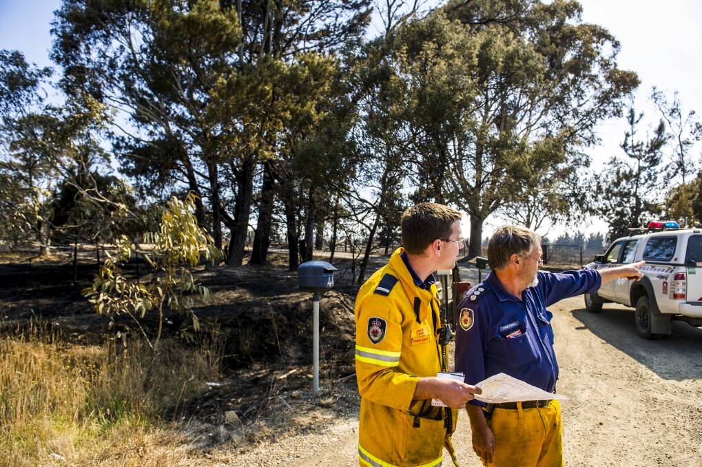 Lewis Conn and Chris Powell discuss the fires at the Kings Highway near Bungendore on January 9, 2013. Photo: Rohan Thomson. 